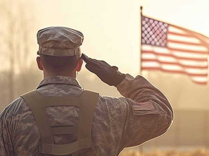 Military person saluting the American flag
